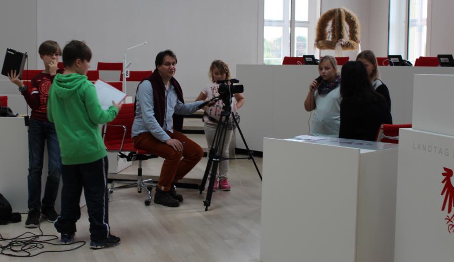 Kinderreporter_innen filmen im Brandenburger Landtag, begleitet von Bildungsreferent Frank Hofmann