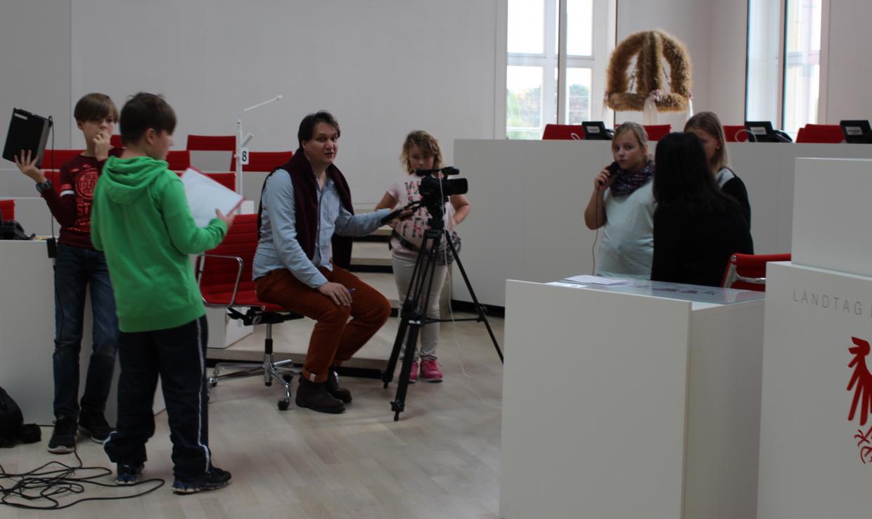 Kinderreporter_innen filmen im Brandenburger Landtag, begleitet von Bildungsreferent Frank Hofmann
